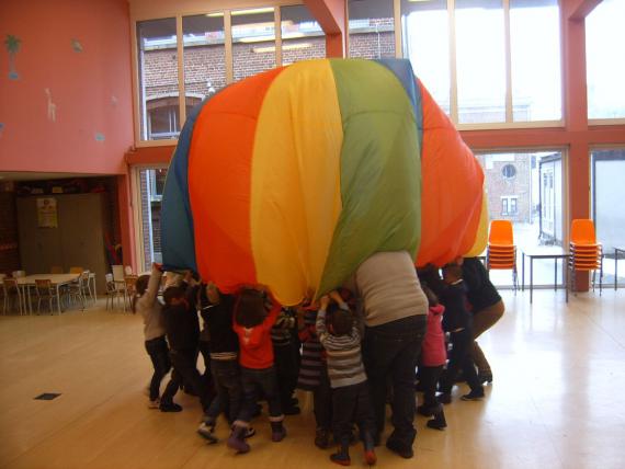 En agitant une toile de parachute, les enfants ressentent de manière ludique l’existence de l’air.