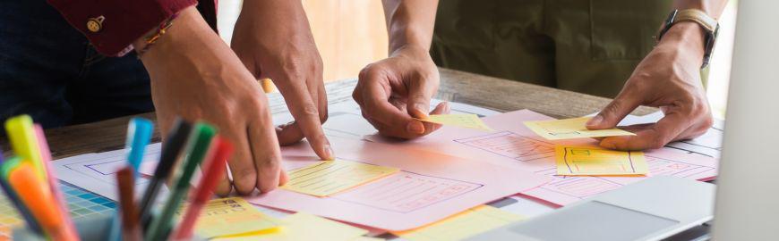 Trois personnes collent des post-it sur une feuille